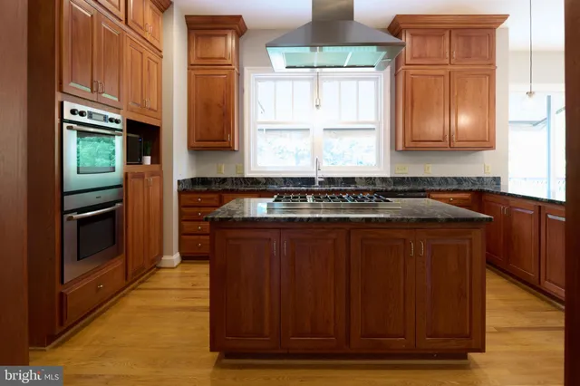 a kitchen with stainless steel appliances granite countertop a sink and cabinets