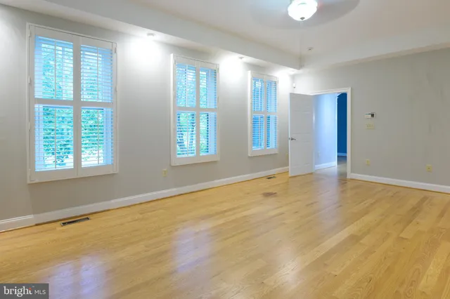 a view of grassy field with benches and trees all around