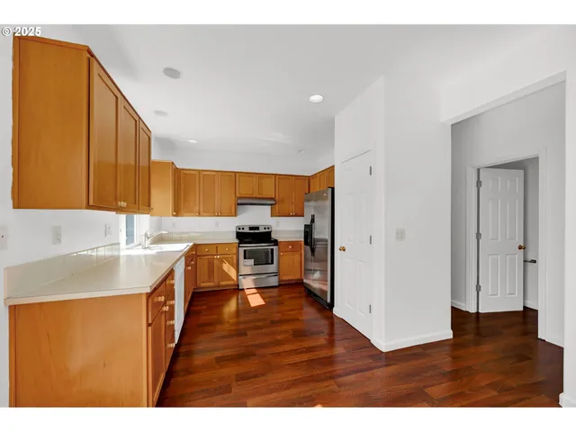 a kitchen with stainless steel appliances granite countertop lots of counter top space and wooden floor