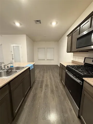 a kitchen with stainless steel appliances and wooden floor