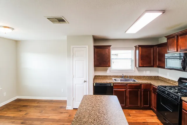 a kitchen with stainless steel appliances granite countertop a stove and a sink