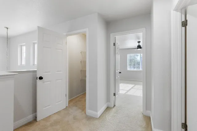 a view of a room with a ceiling fan and wooden floor