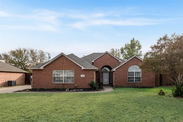 a view of a house with a yard and fence