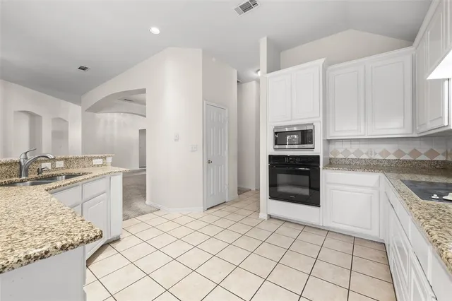 a large kitchen with a stove a sink and a refrigerator