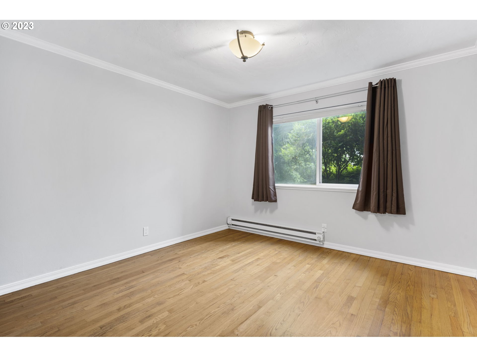8400 Southwest Canyon Lane, Unit 6 Portland, OR 97225 - Photo 12 of 19 a view of an empty room with wooden floor and a window
