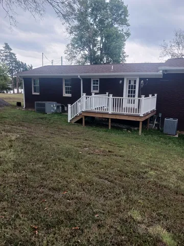 a view of a house with a yard and sitting area