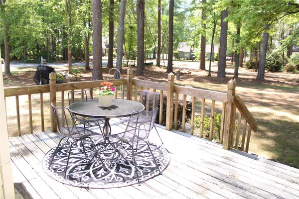 a view of a patio with table and chairs with wooden floor and fence