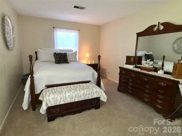 a bedroom with a bed and large windows