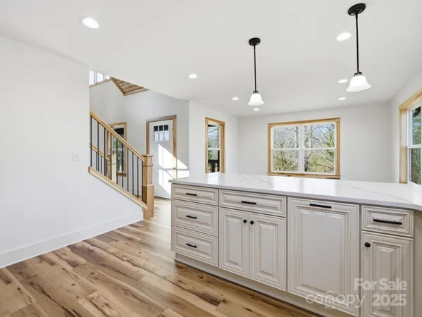a kitchen with granite countertop a stove a sink and a chandelier