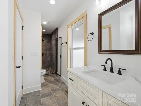 a bathroom with a sink a toilet and a mirror