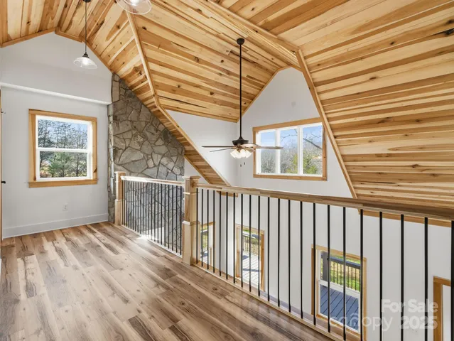 a view of empty room with wooden floor and fan