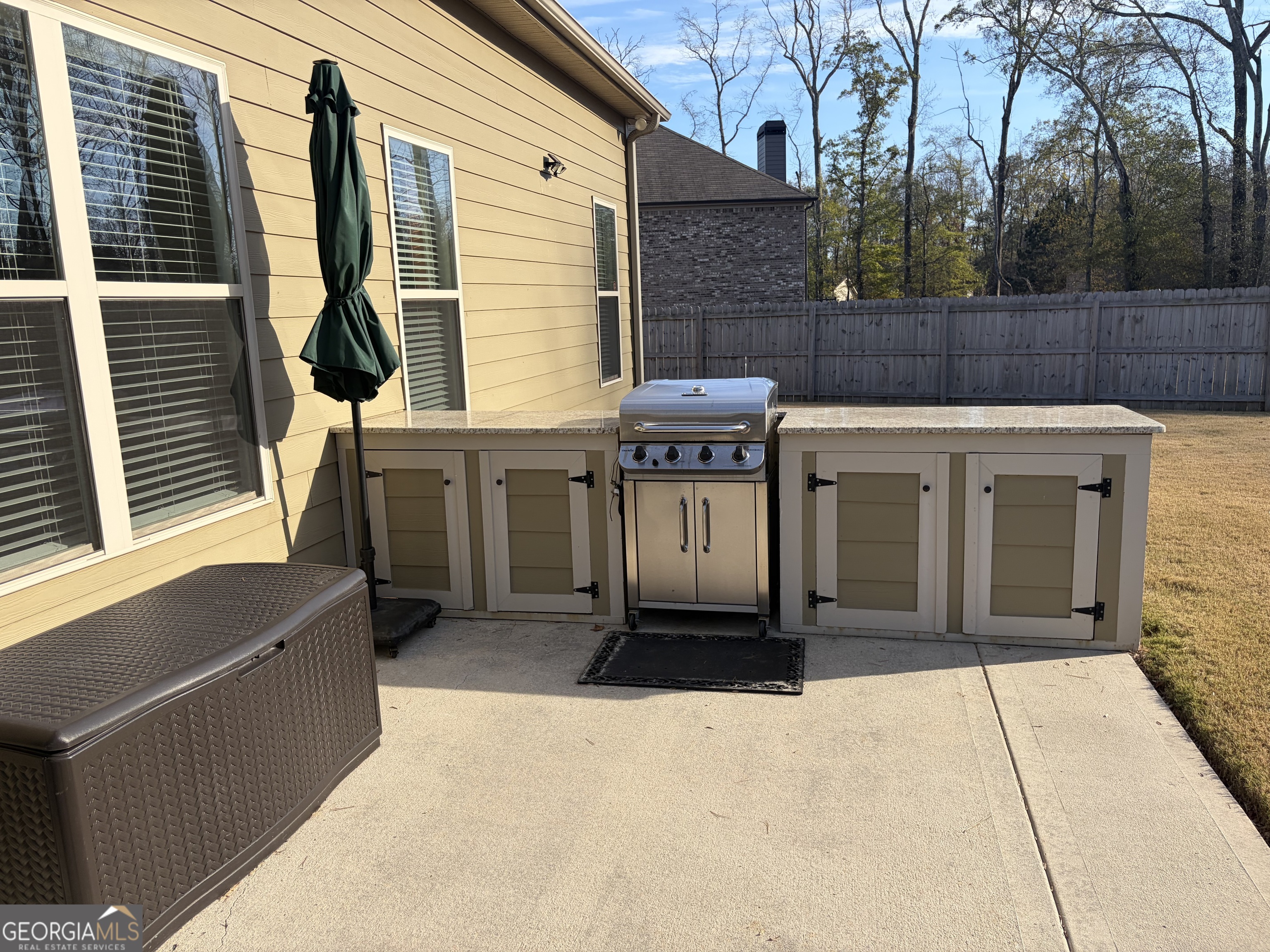 156 Elkins Boulevard Locust Grove, GA 30248 - Photo 27 of 36 a view of a house with barbeque grill and wooden fence