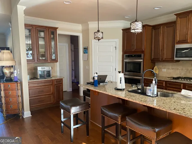 a kitchen with granite countertop a stove a sink and a refrigerator