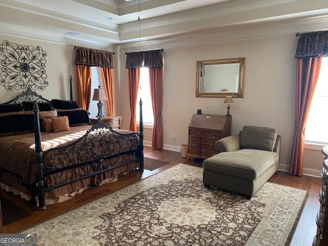 a bedroom with a bed lamp and a large window