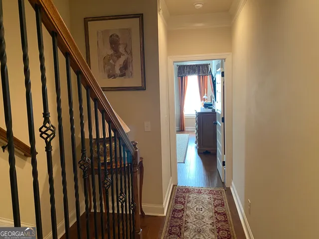 a view of a hallway with wooden floor and stairs