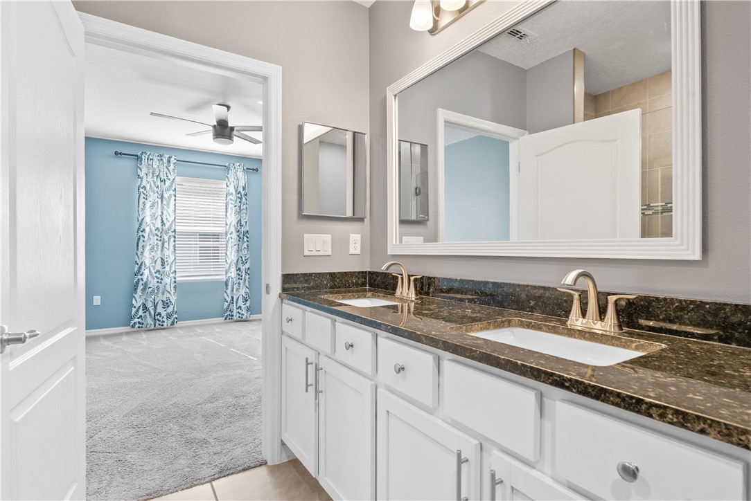 6045 Red Maple Manor Vero Beach, FL 32966 - Photo 16 of 36 a bathroom with a granite countertop sink double vanity and a mirror