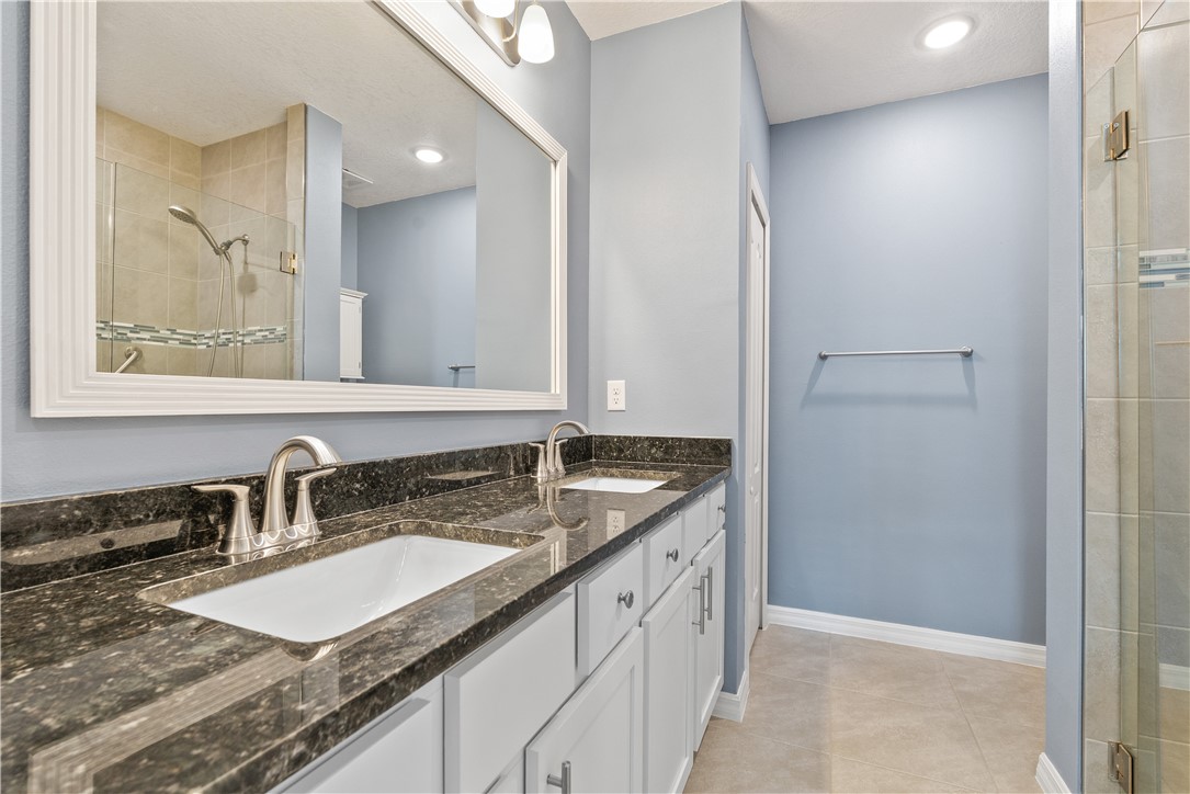 6045 Red Maple Manor Vero Beach, FL 32966 - Photo 17 of 36 a bathroom with a granite countertop sink and a mirror