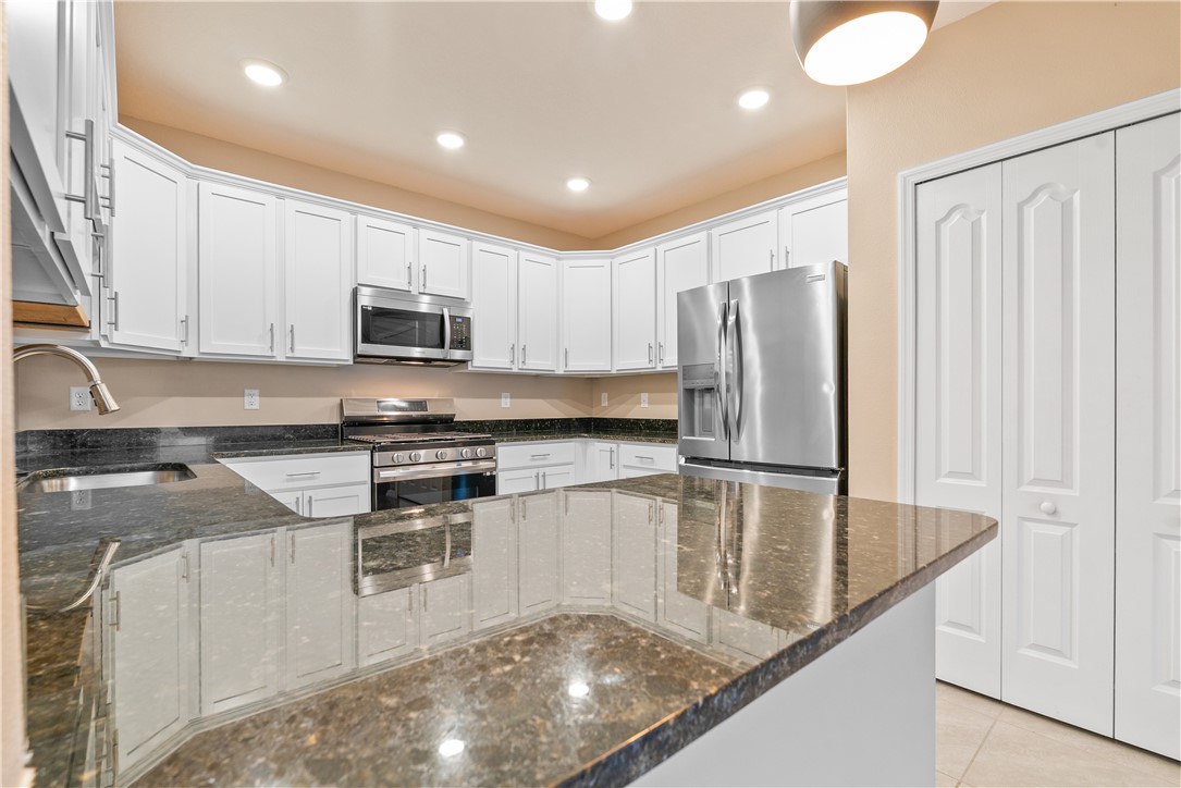 6045 Red Maple Manor Vero Beach, FL 32966 - Photo 10 of 36 a kitchen with kitchen island a counter top space cabinets and stainless steel appliances