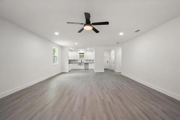 a view of empty room with wooden floor and window