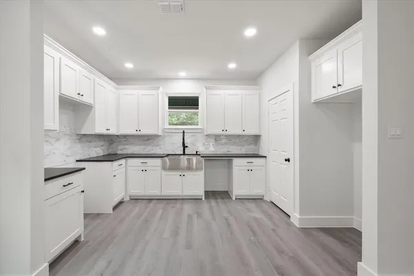 a kitchen with granite countertop white cabinets and white appliances