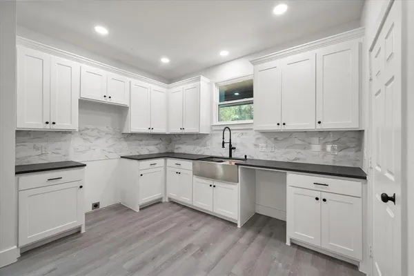 a kitchen with granite countertop white cabinets and white appliances