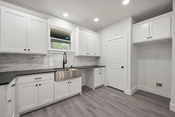 a kitchen with stainless steel appliances granite countertop a sink and cabinets with wooden floor