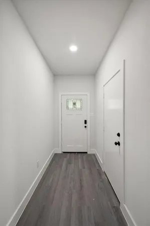 a view of an empty room with wooden floor