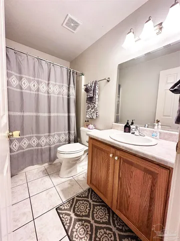 a spacious bathroom with a double vanity sink toilet mirror and shower