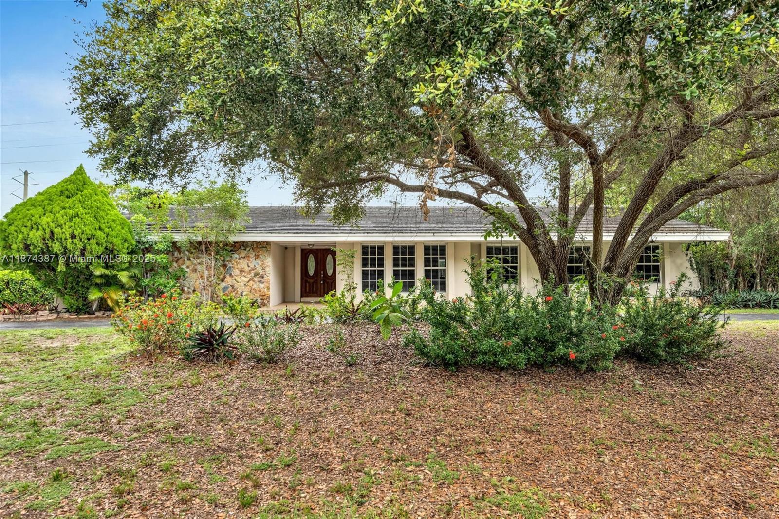 14780 Old Cutler Road, Unit 14780 Palmetto Bay, FL 33158 - Photo 2 of 16 a front view of a house with garden