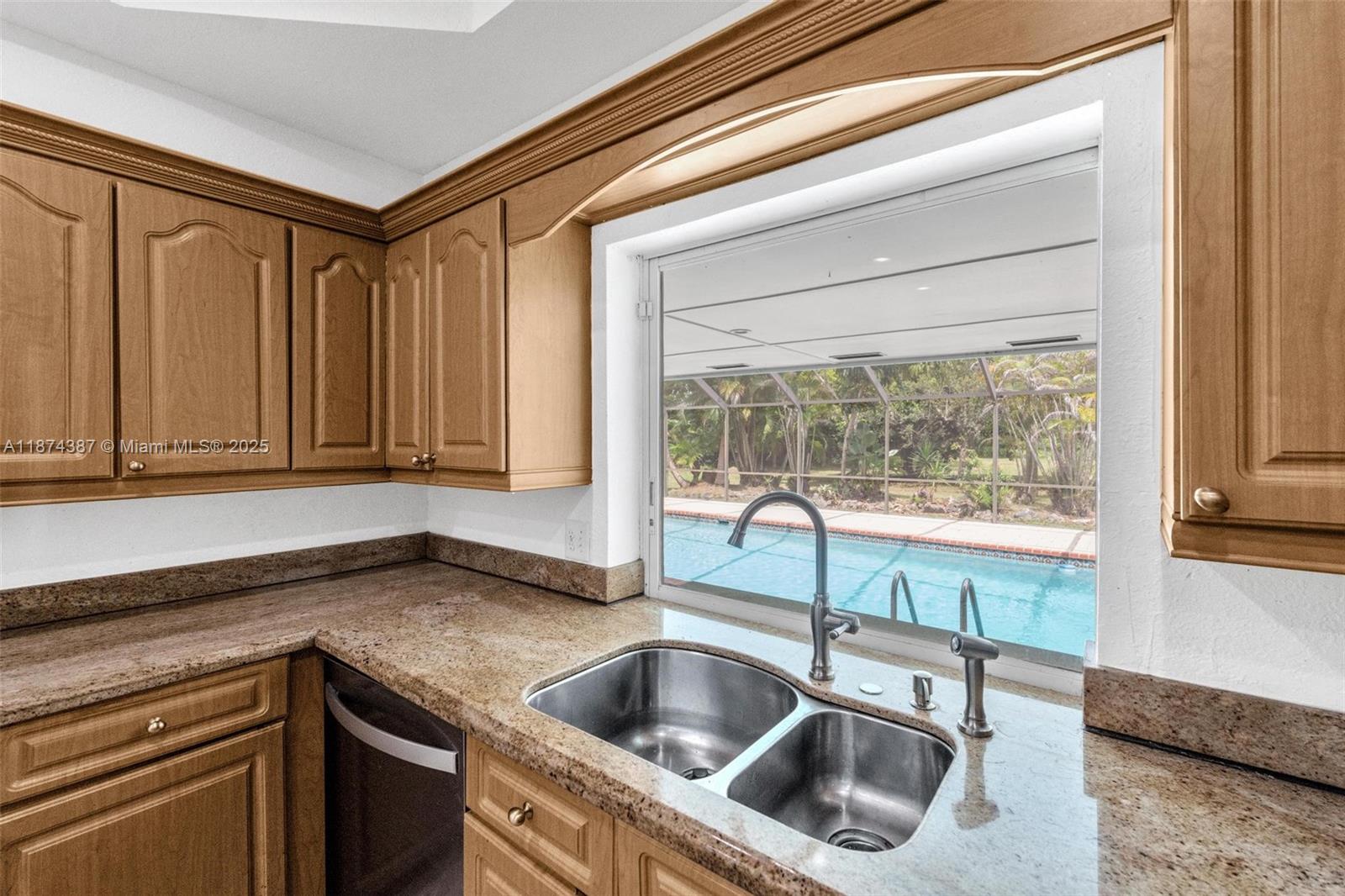 14780 Old Cutler Road, Unit 14780 Palmetto Bay, FL 33158 - Photo 8 of 16 a kitchen with granite countertop a sink and a refrigerator
