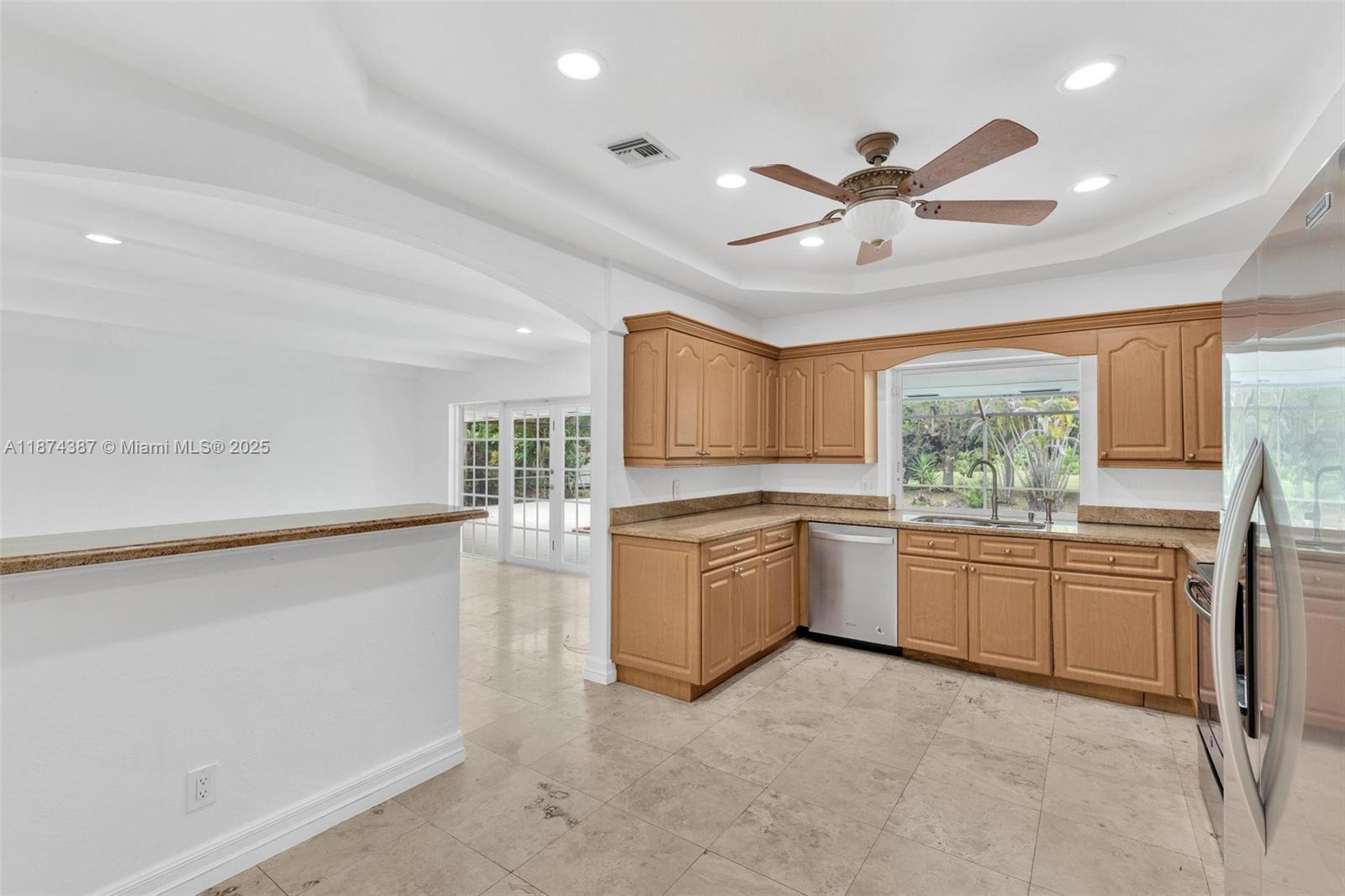 14780 Old Cutler Road, Unit 14780 Palmetto Bay, FL 33158 - Photo 10 of 16 a kitchen with granite countertop a stove a sink dishwasher a refrigerator and white cabinets with wooden floor
