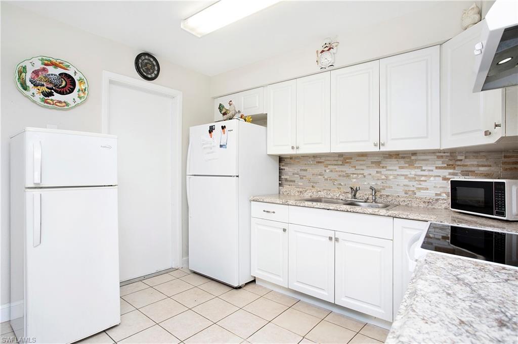 515 York Road Lehigh Acres, FL 33936 - Photo 15 of 22 a kitchen with a refrigerator and white cabinets