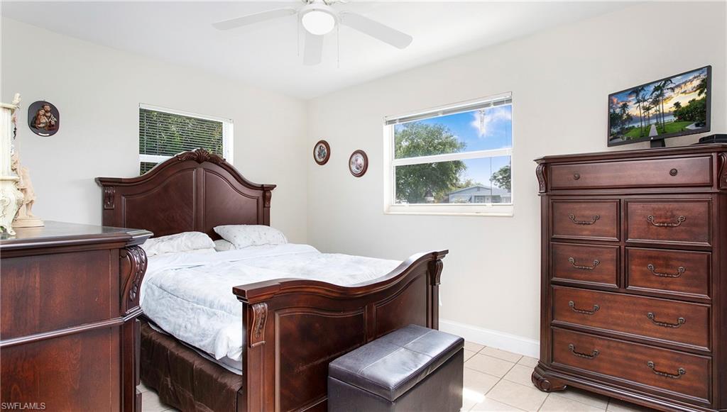 515 York Road Lehigh Acres, FL 33936 - Photo 10 of 22 a bedroom with a bed and a flat tv screen on dresser