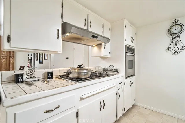 a kitchen with stainless steel appliances a sink and a white cabinets