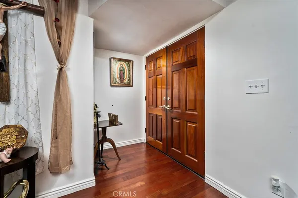 a view of a hallway with wooden floor and furniture