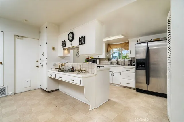 a kitchen with white cabinets and white appliances