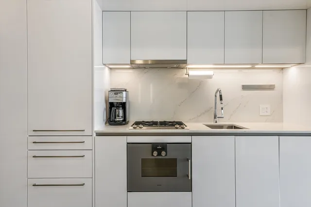 a kitchen with granite countertop white cabinets and white appliances