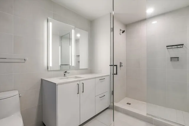a bathroom with a double vanity sink toilet and shower