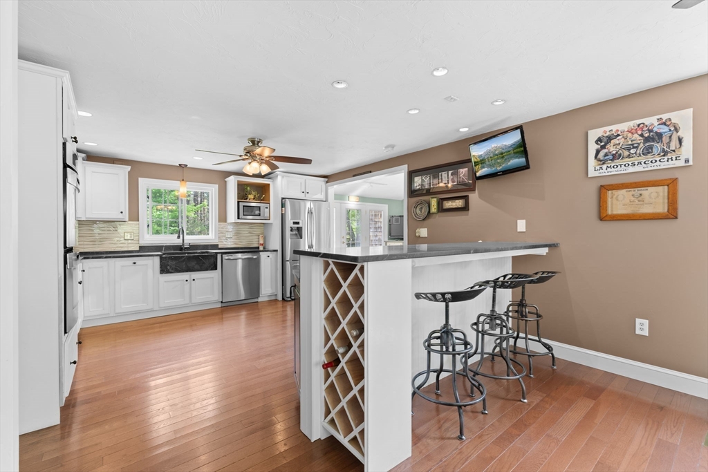 103 Maple Street Plympton, MA 02367 - Photo 3 of 41 a view of a kitchen with dining table chairs wooden floor and stainless steel appliances