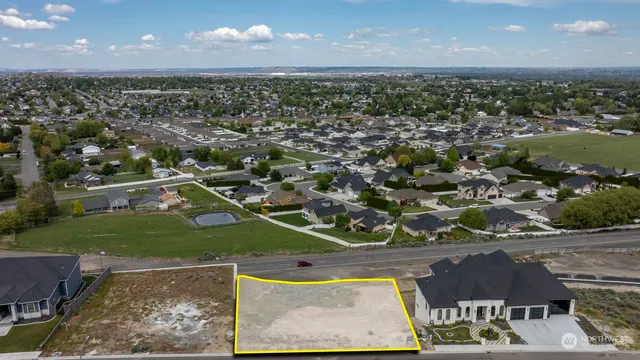 an aerial view of residential houses with outdoor space and lake view