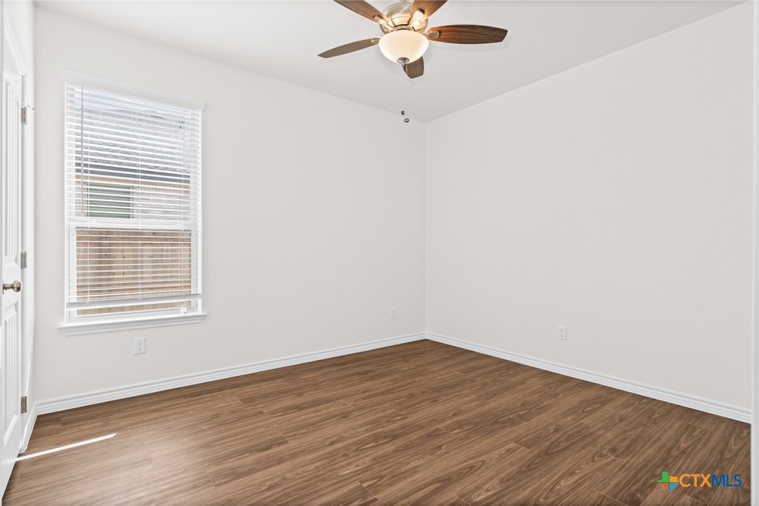 5112 Rose Gdn Loop Killeen, TX 76542 - Photo 13 of 20 an empty room with wooden floor fan and windows