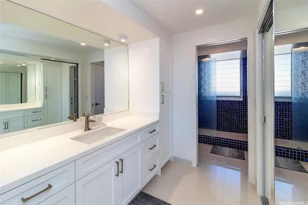 a spacious bathroom with a shower a sink and a mirror