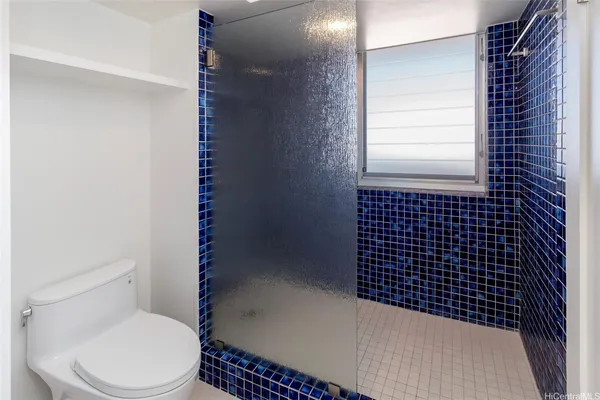 a bathroom with a toilet and a shower
