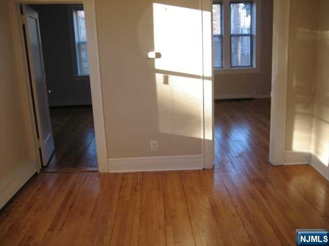 75 Barkley Avenue, Unit 4 Clifton, NJ 07011 - Photo 4 of 10 wooden floor in an empty room with a window