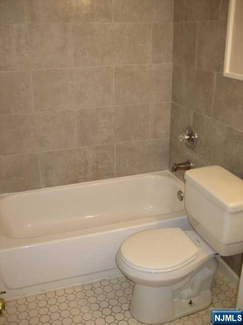 75 Barkley Avenue, Unit 4 Clifton, NJ 07011 - Photo 8 of 10 a bathroom with a toilet and a bath tub