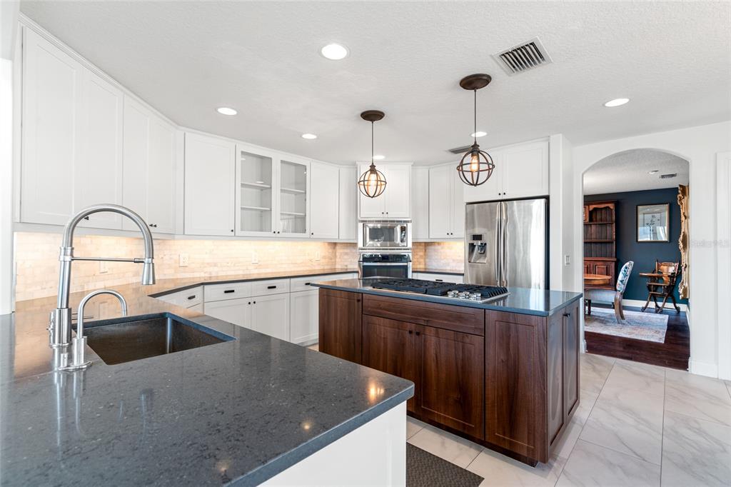 6315 Marbella Boulevard Apollo Beach, FL 33572 - Photo 13 of 83 a kitchen with granite countertop a sink a counter top space stainless steel appliances and cabinets