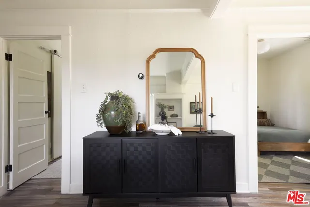 a view of a living room with a mirror and wooden floor