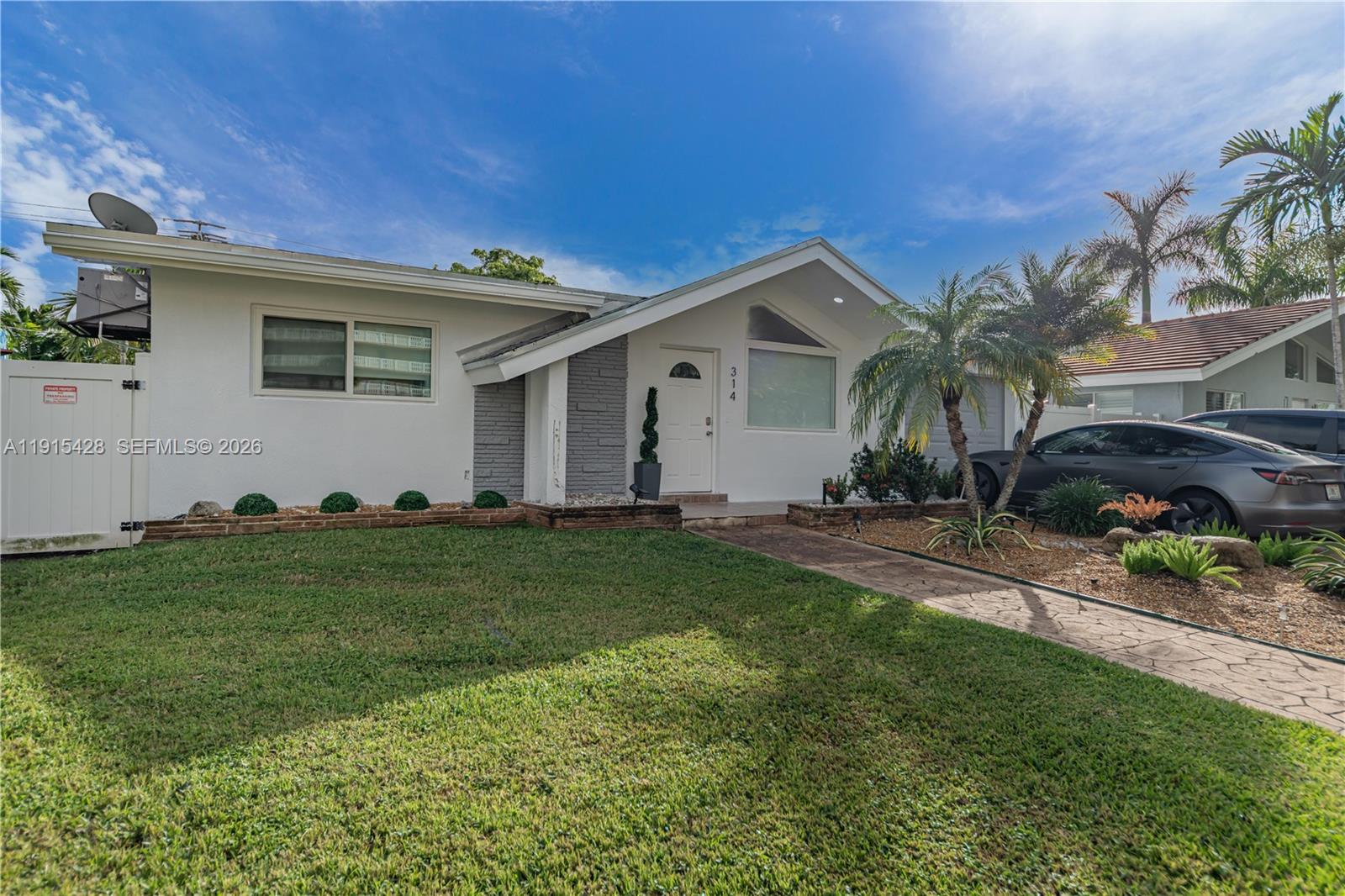 314 Southeast 3rd Street Dania Beach, FL 33004 - Photo 1 of 26 a front view of a house with a garden
