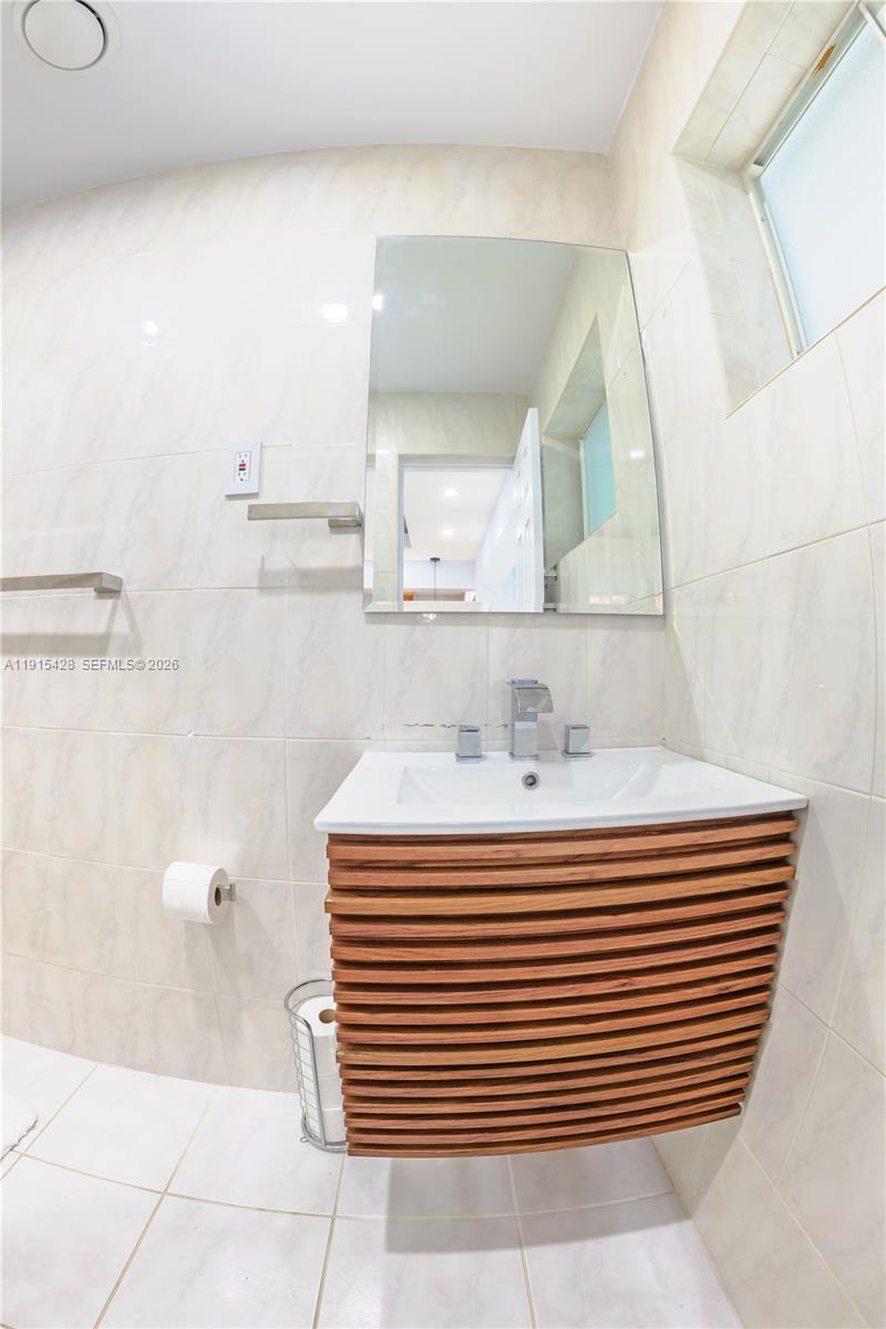 314 Southeast 3rd Street Dania Beach, FL 33004 - Photo 15 of 26 a bathroom with a sink a mirror and a shower