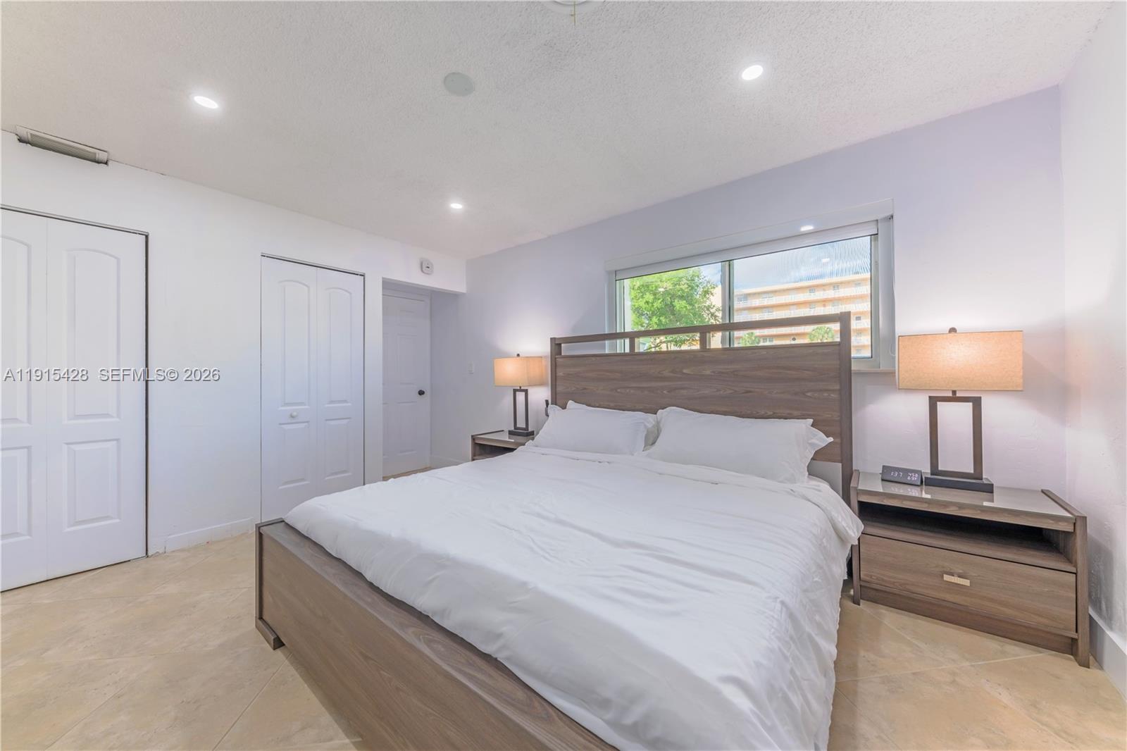 314 Southeast 3rd Street Dania Beach, FL 33004 - Photo 21 of 26 a bedroom with a bed and a lamp